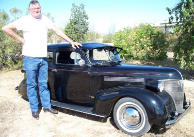 Ernie posing with his miniature 1939 Chevy Sedan.