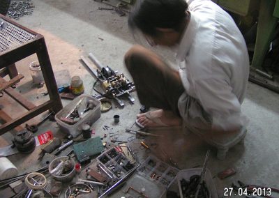 Alternate view of Iqbal assembling the engine.