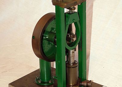 A green vertical steam engine.