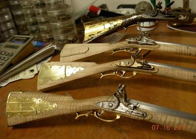 Several nearly finished scale model long rifles.