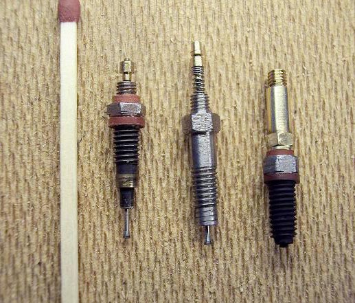 Miniature injectors with a match for scale reference.