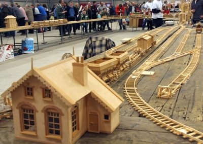 A wooden railway station sits by the tracks.