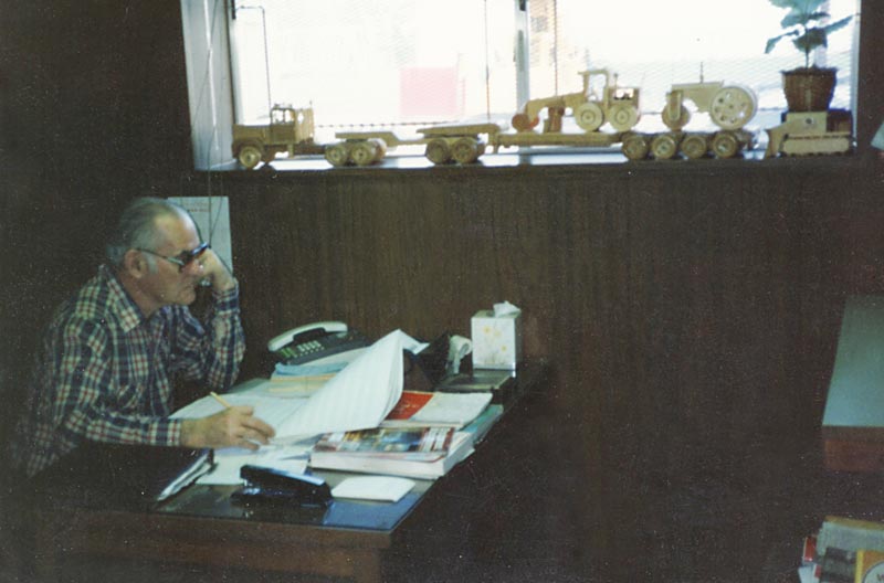 Perry sits in his old office, with several wooden models below the window.