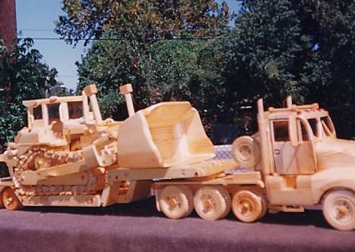 A wooden model tractor and trailer.