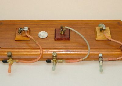 A display board holding three tiny steam engines.