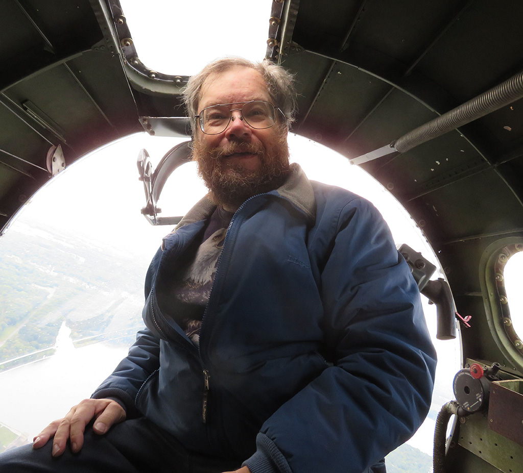 Chris sits in the nose of a B-17 during flight.
