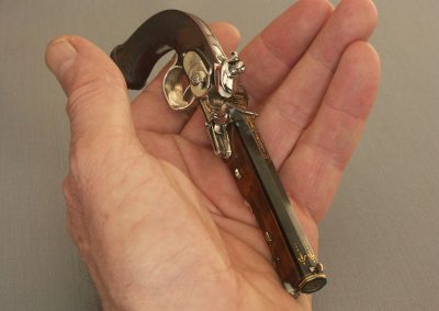 Michel holds the miniature Boutet pistol in hand.