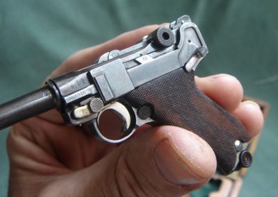 A close-up reveals details of the markings on this mini Luger.