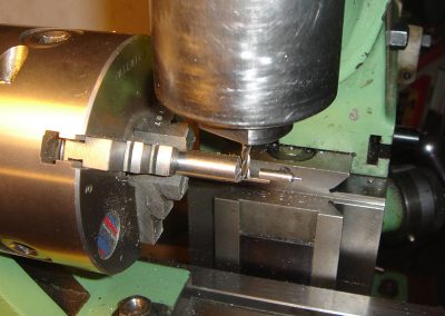 Mill cutting (parting) the completed firing pin from a raw carbon steel bar.