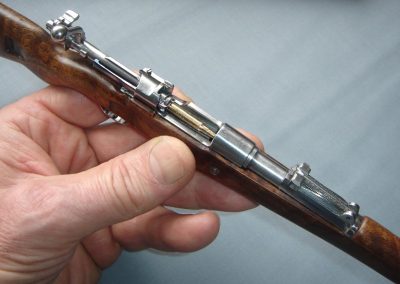 A miniature cartridge is ready to be loaded into the firing chamber.