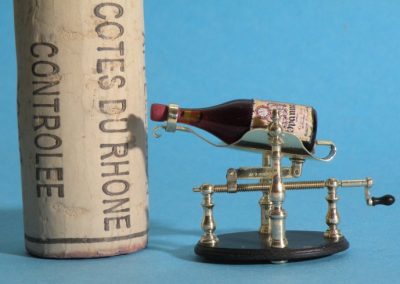 A tiny wine pourer is seen next to a full-size cork.