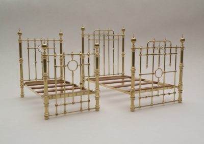 Two ornate 4-poster brass beds in miniature.