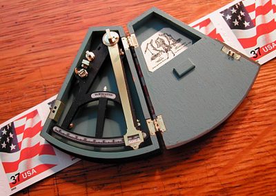A miniature octant in a custom hinged box.