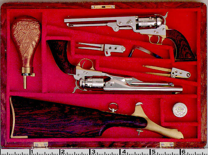 A cased set including two Colt Percussion Revolvers and a shoulder stock.