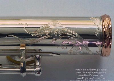 A silver flute with engraved design.