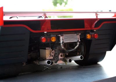 The rear end of the race car shows the wing and tail lights.