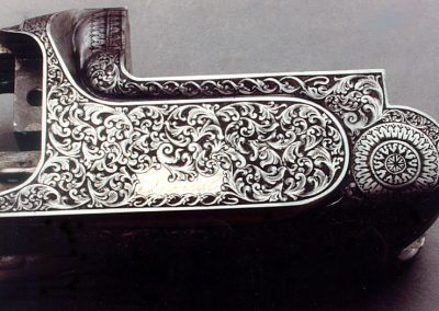 This over/under shotgun by Perazzi is engraved with an intertwining early American style scroll.