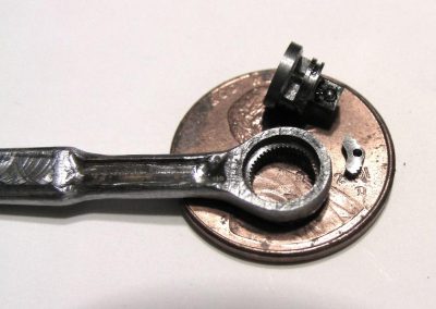 The mini ratchet wrench sits on a US penny for scale reference.