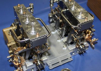 Miniature dual triple-expansion steam engines.