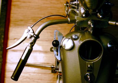 A close-up shows the brake lever, gas cap, and gated shift lever.