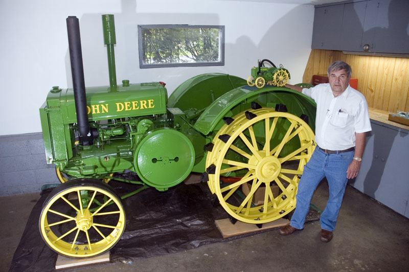 Jerry's 1/8 scale John Deere tractor sits on the fender of the full-size original.