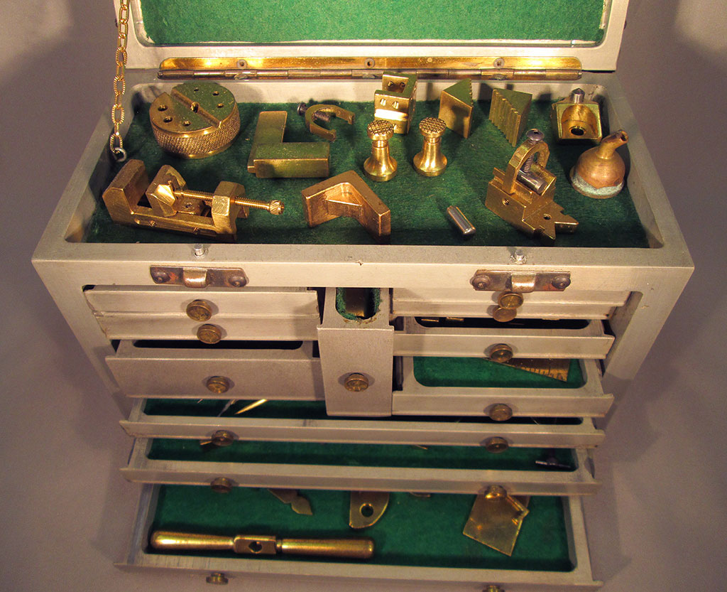 With the lid open, several miniature machinist's tools can be seen.