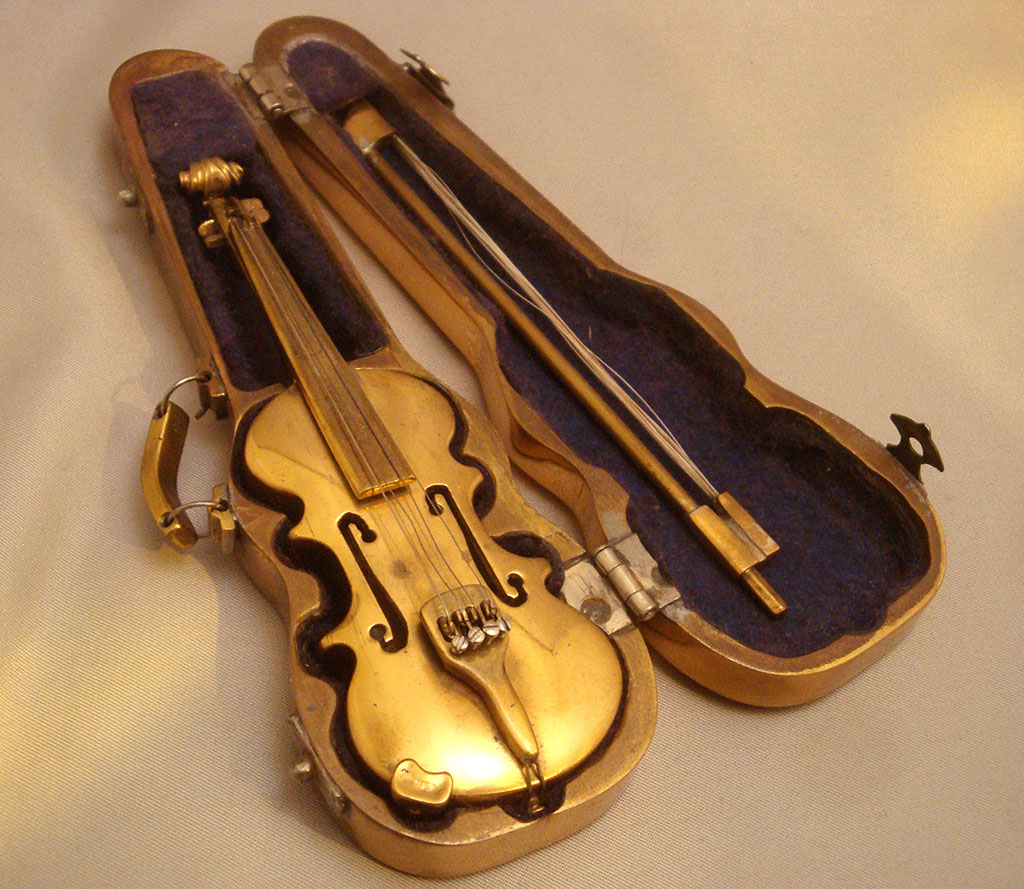 Abraham's miniature violin sits in its open case.