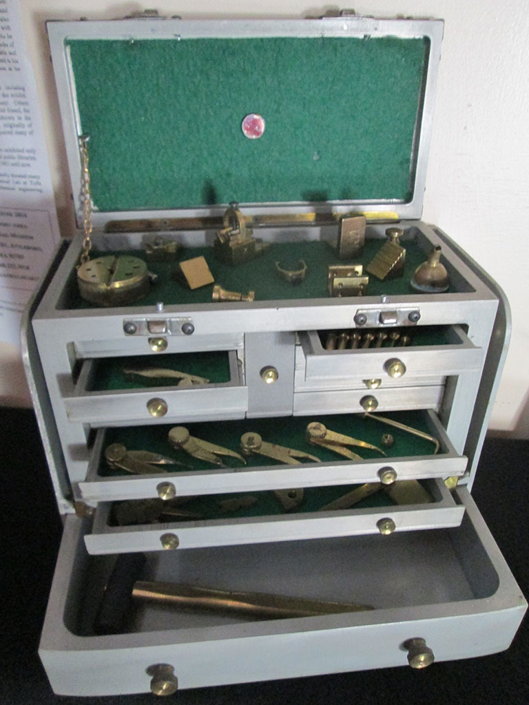 The open, felt-lined drawers reveal a number of miniature machinist's tools.