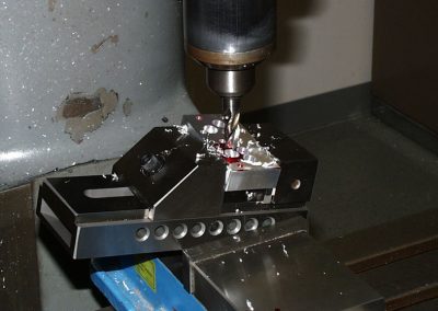 Machining the spark plug hole and counterbore at a compound angle.