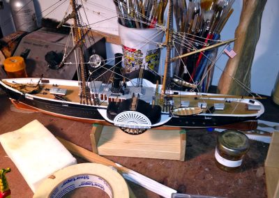 This model of a sidewheel riverboat combines steam and sail.
