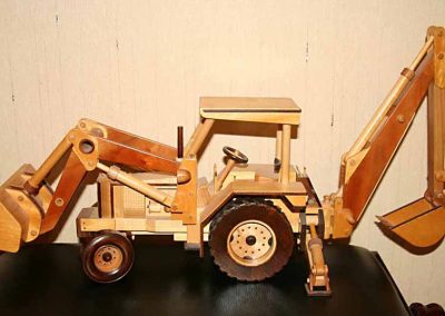 A wooden model backhoe tractor.