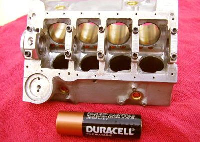 The unfinished engine block with a Duracell battery for scale reference.
