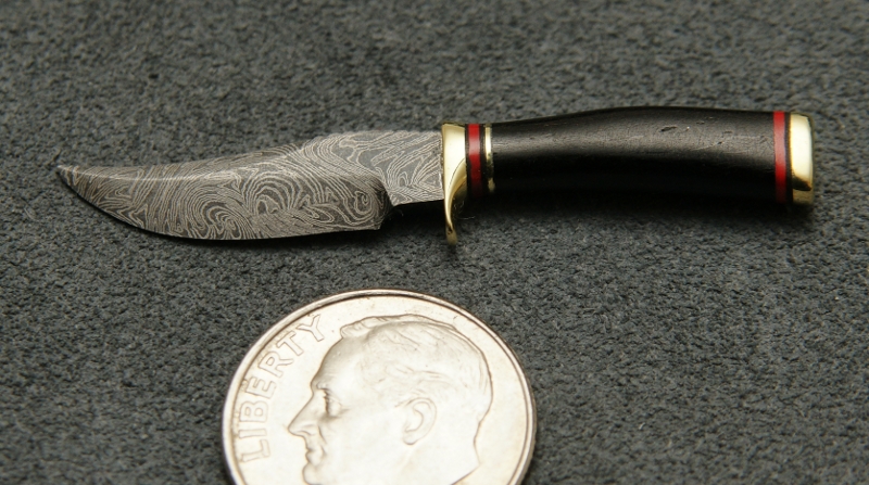 This miniature fixed blade knife features Damascus steel. 