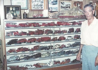 Tom poses with a display of some of his vehicles in his home in 1992.