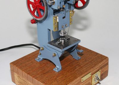 A small model of an industrial punch press.