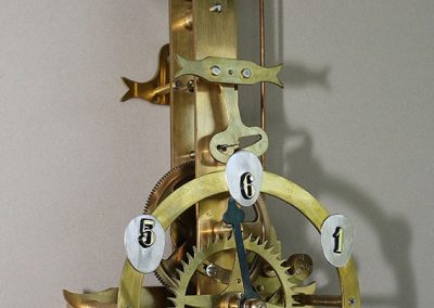 This brass geared clock is powered by gravity.