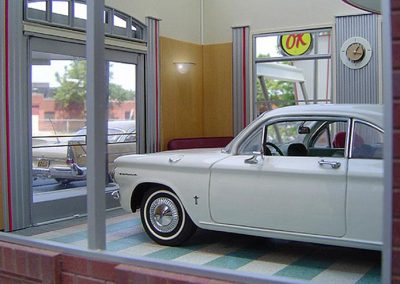 An economical 1960 Corsair in a scale model showroom.