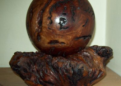 This is a 5" wooden ball on a stand.