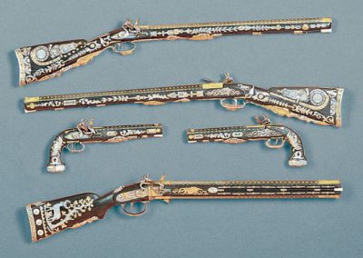 An array of miniature carbines and dueling pistols.