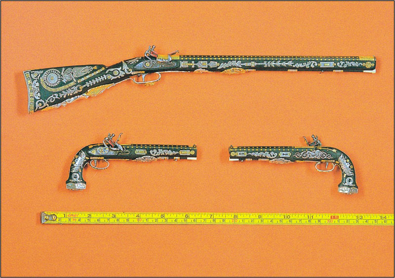 A miniature rifle and pair of matching pistols. 