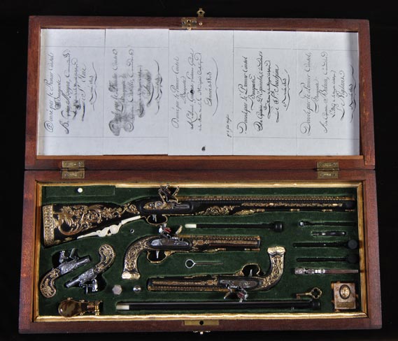 A magnificently cased five-piece garniture of gold mounted arms. 