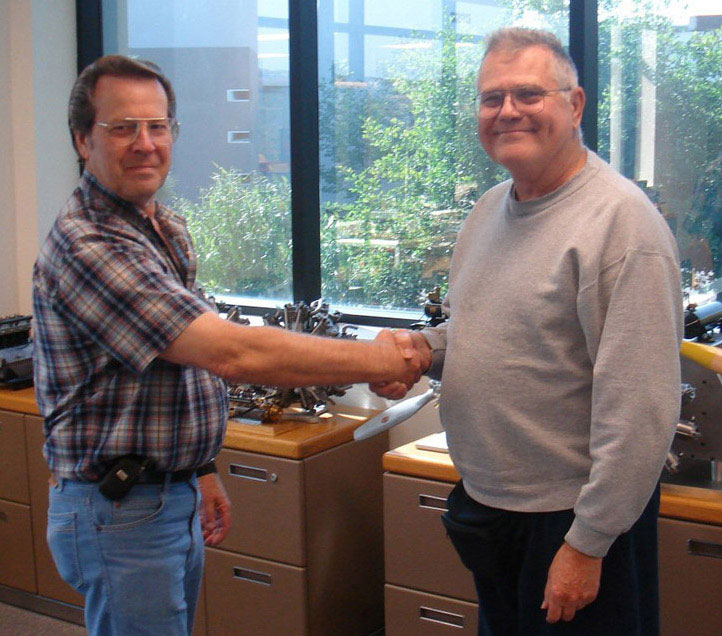 Paul Knapp (left) shakes hands with museum founder Joe Martin.
