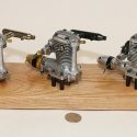 Three Hirtenberger Patronen VT21 engines on a wooden display base.