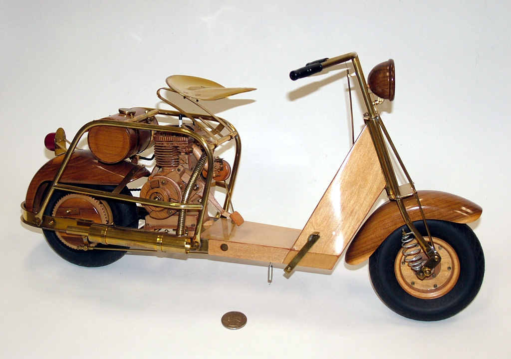 A 1/4 scale Cushman 711 scooter made from wood and brass.
