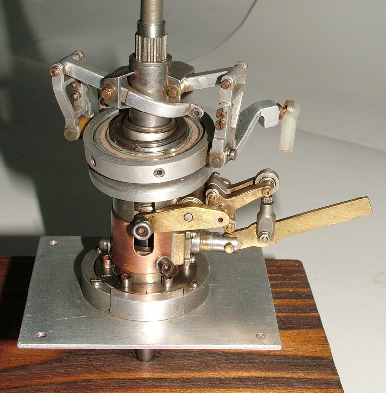 A brass and aluminum miniature Bell helicopter rotor mechanism.