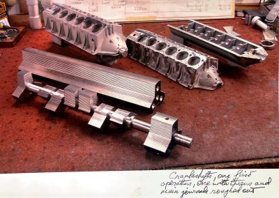 Two crankshafts at different stages of machining. The one in front has the throws and main journals roughed out.